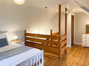 a bedroom with a large bed and a staircase at Innish Beag - Uk38782 in Clachan