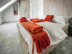 a large bed with an orange blanket on it at Apartment 5 - Uk51650 in Maldon