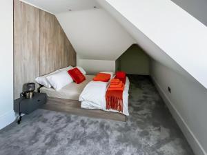 a attic bedroom with two beds with red pillows at Apartment 5 - Uk51650 in Maldon