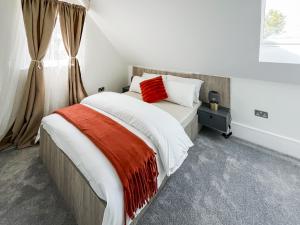 a bedroom with a large bed with a red pillow at Apartment 5 - Uk51650 in Maldon +3 photos