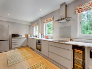 a large kitchen with white cabinets and a sink at Ash Hill - Uk36199 in Fordingbridge