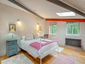 a bedroom with a white bed with a pink blanket at Ash Hill - Uk36199 in Fordingbridge +16 photos