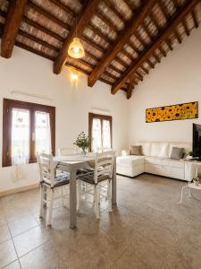a living room with a table and chairs and a couch at Baco Da Seta Residence con Piscina - Venezia Mestre in Mestre