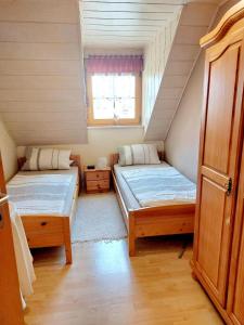 a small room with two beds and a window at Ferienwohnung Forster in Moosbach