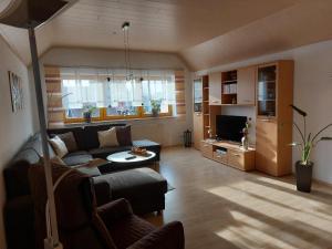 a living room with a couch and a tv at Ferienwohnung Forster in Moosbach