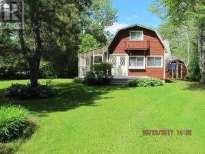 a house with a large lawn in front of it at 2 Bed Rustic Retreat at Bois Joli Beach in Grand Barachois