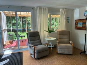 two chairs and a table in a living room at 2 Bed Rustic Retreat at Bois Joli Beach in Grand Barachois