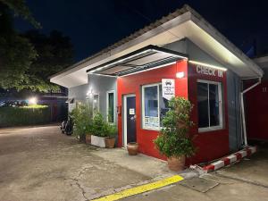 a red building with a sign that reads check inn at Love Box Resort in Samutprakarn