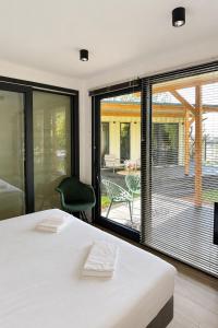 a bedroom with a white bed and a large window at Luxury Lake Cabin in Alphen