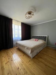 a bedroom with a bed with pink shoes on it at Kamil Guest House in Shabdan