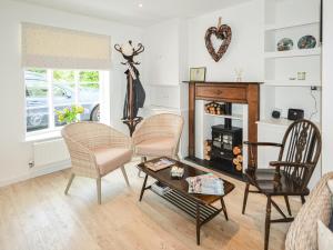 a living room with chairs and a fireplace at Jan Dee Cottage in Ventnor