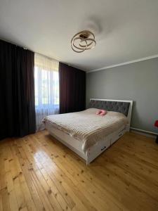 a bedroom with a bed with pink shoes on it at Kamil Guest House in Shabdan