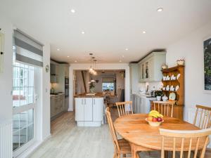 a kitchen and dining room with a wooden table and chairs at Jan Dee Cottage in Ventnor