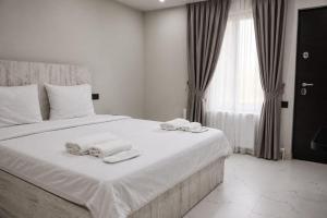 a bedroom with a white bed with towels on it at SkyGate Hotel in Pʼarakʼar +1 photo