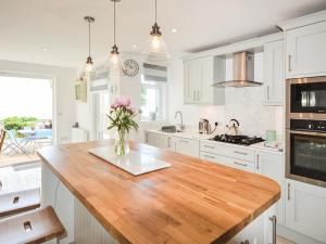 a kitchen with a vase of flowers on a counter at Jan Dee Cottage in Ventnor