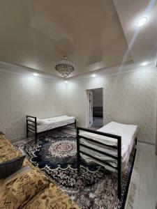 a room with two beds and a rug at Kamil Guest House in Shabdan +8 photos