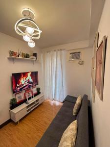 a living room with a couch and a flat screen tv at Arezzo Place in Davao City
