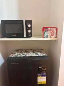 a microwave sitting on top of a box on a shelf at Arezzo Place in Davao City
