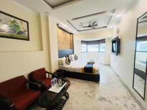 a hotel room with a bed and a couch and a table at Hotel Dharma Heights - Sector 11 Noida in Noida