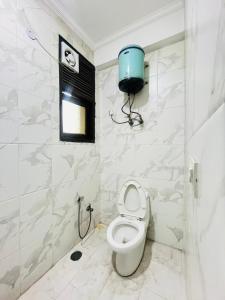 a bathroom with a toilet and a shower stall at Hotel Dharma Heights - Sector 11 Noida in Noida +20 photos