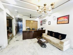 a living room with a couch and a table at Hotel Dharma Heights - Sector 11 Noida in Noida