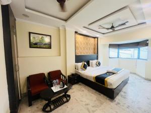 a hotel room with a bed and a chair at Hotel Dharma Heights - Sector 11 Noida in Noida