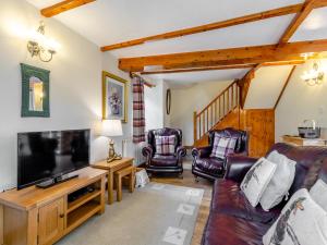a living room with a couch and a flat screen tv at Lavender Cottage - Ukc6677 in Bettws-yn-Rhôs