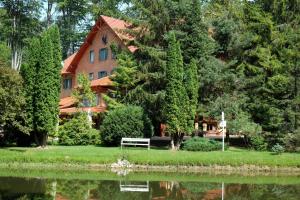 a house next to a body of water at Sebesvi­z Panzió in Répáshuta