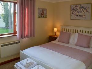 a bedroom with a white bed and a window at Solace - Ukc2122 in Stalham