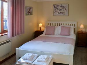 a bedroom with a white bed with two towels on it at Solace - Ukc2122 in Stalham