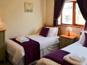 a bedroom with two beds and a window at Solace - Ukc2122 in Stalham +6 photos