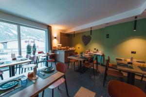 a restaurant with tables and chairs and a large window at mySHH Smart in Vigo di Fassa