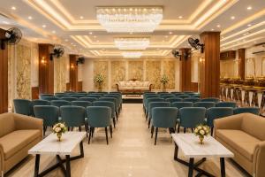 a large room with rows of chairs and a couch at Hotel Kanak in Gangānagar