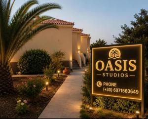 a sign in front of a building with a house at Oasis Studios Skala Kallonis in Skala Kallonis