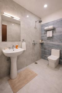 a bathroom with a sink and a toilet and a mirror at Hotel R-A-M-A-N-S-H GRAND INN - Beside Ram Mandir Ayodhya 96,7000,2101 in Ayodhya