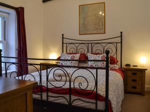 a bedroom with a black bed with red pillows at Croft Cottage in Braithwaite +7 photos