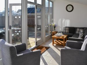 a living room with two couches and a table at Riverside - Ukc2296 in Stalham