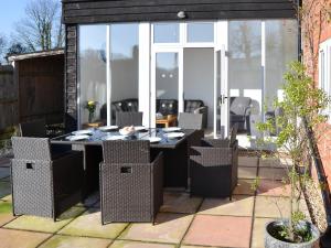 a patio with a table and chairs in a yard at Riverside - Ukc2296 in Stalham