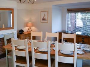 a dining room with a wooden table and chairs at Riverside - Ukc2296 in Stalham +17 photos