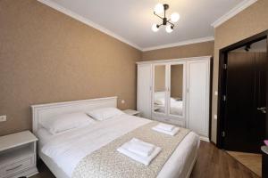 a bedroom with a bed with two towels on it at Home Inn Apartments Your house Jikia-Central Tbilisi in Tbilisi City