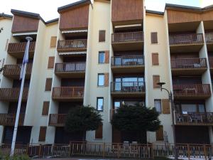 un immeuble d'appartements avec balcon et arbres dans l'établissement Le Plazza, à Valberg