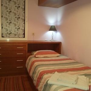 a small bedroom with a bed and a dresser at Apartamento Vai Vem in Madalena do Mar