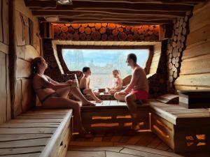 a group of people sitting in a cabin window at Hotel Kocourkov in Hlinsko