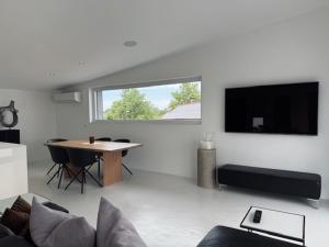 a living room with a table and a flat screen tv at Aparthotel Othello in Dingolfing