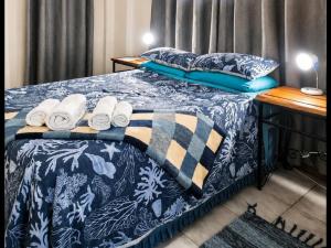 a bed with towels and pillows on top of it at Art Guest House in Lutzville