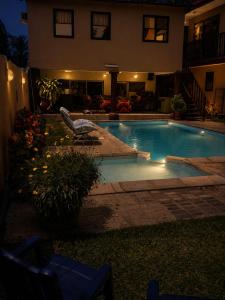 a swimming pool in front of a house at night at Roc Heights in Bakau