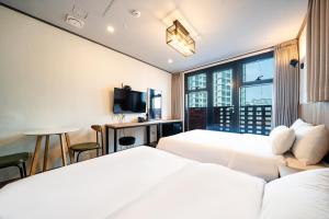 a hotel room with two beds and a window at Benikea Hotel Kakao in Seoul +22 photos
