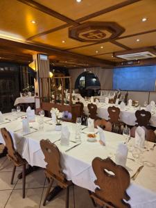 a dining room with white tables and chairs at Hôtel Restaurant AU SOLEIL in Wahlbach