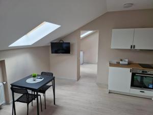 a living room with a table and chairs and a kitchen at FB Apartamentai in Plungė +18 photos