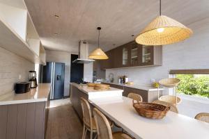 a kitchen with a counter with chairs and two lights at Casas Punta Costanera in Pichilemu
